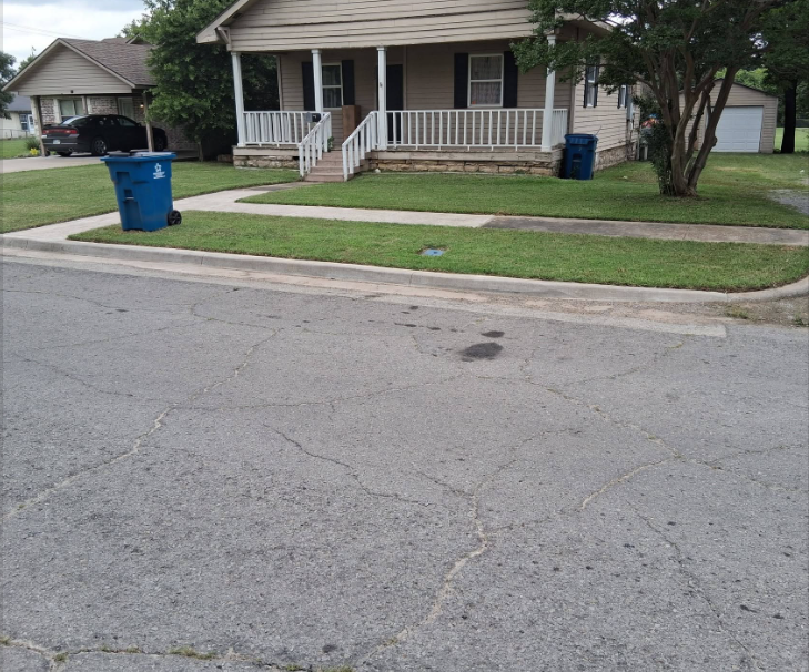 Front lawn mowed and edged along the sidewalk of a tan home