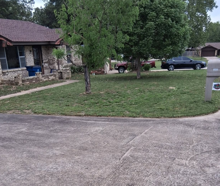 Corner lot mowed and edged along a wide concrete driveway
