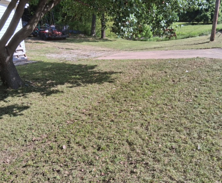 Crew member mowing a residential lawn in McAlester, Oklahoma
