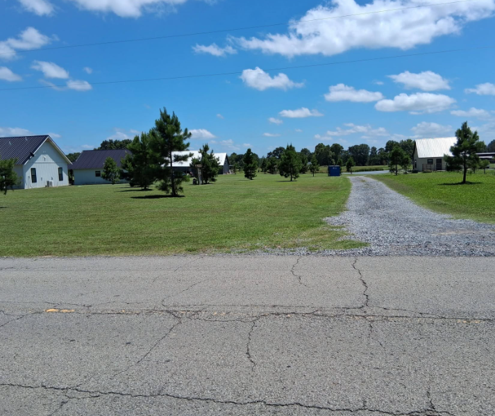 Commercial property lawn mowed along a gravel drive and roadway