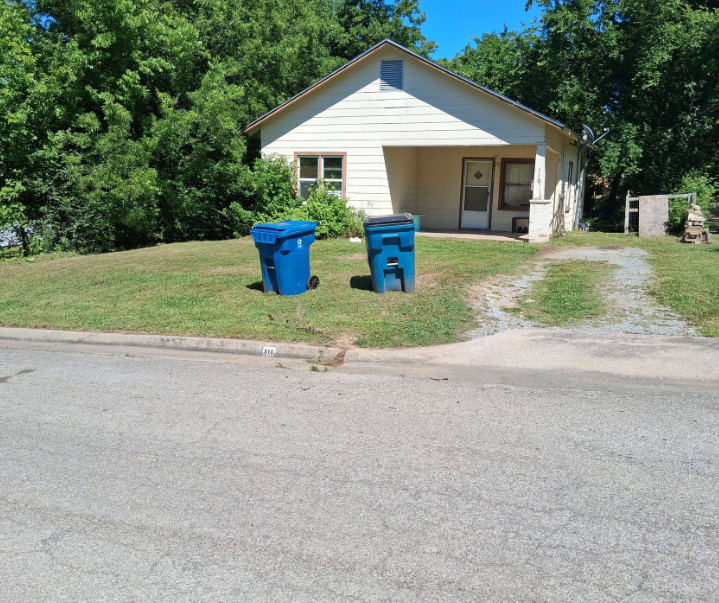 Front lawn mowed and edged to the curb at a cream sided house in McAlester, OK