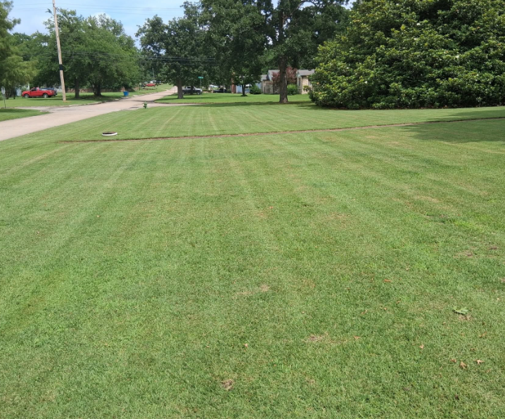 Large corner lot mowed in even passes down to the street