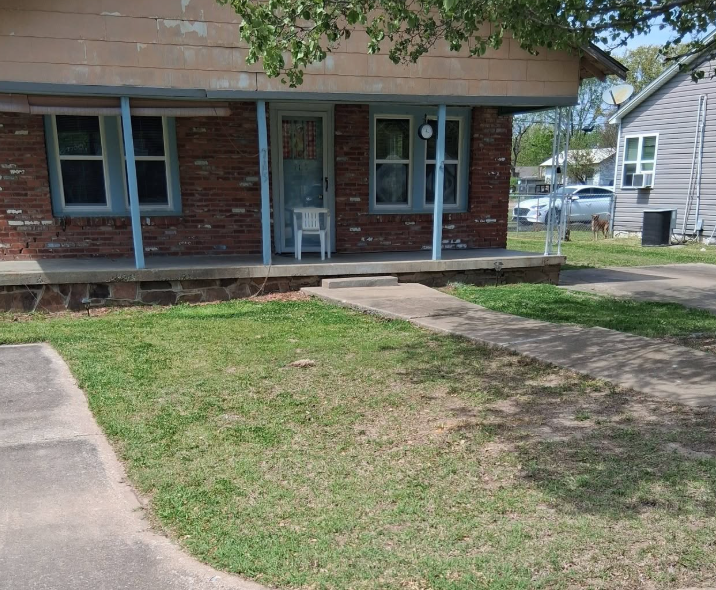 Front yard mowed and trimmed along the walkway of a brick home