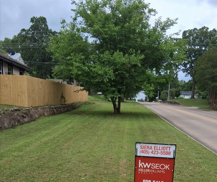 Roadside lot mowed and trimmed along a new privacy fence