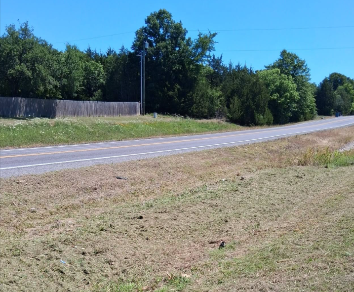 Highway right of way mowed clean along a fence line and roadway
