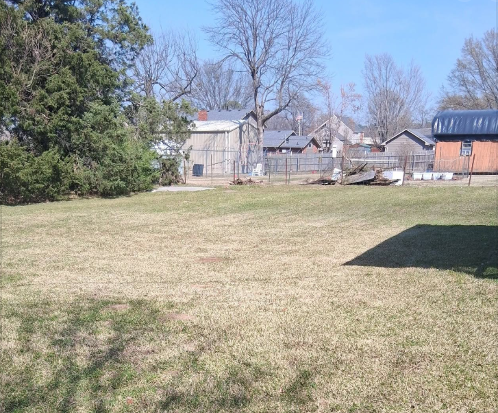 Large open back lot mowed evenly down to the fence line in winter
