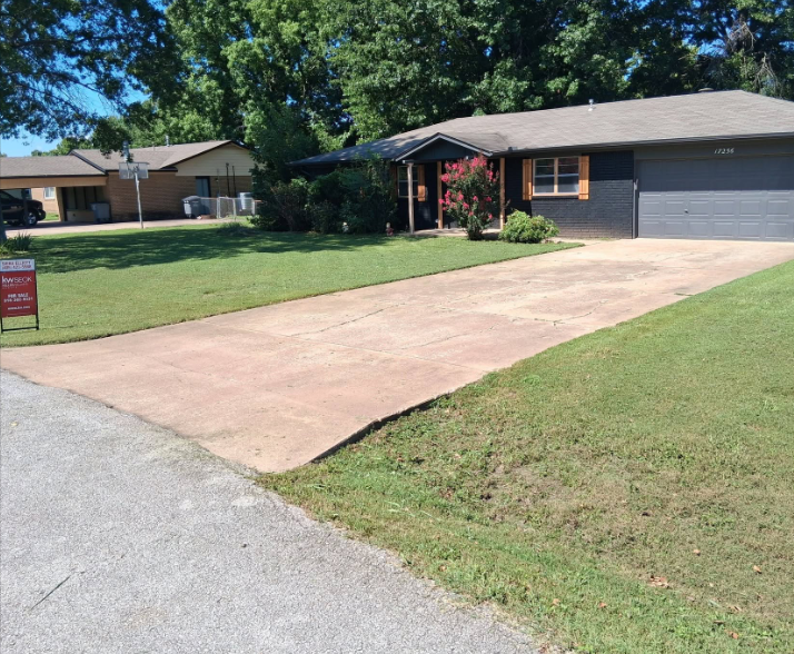 Front lawn mowed and trimmed at a brick home with a long driveway