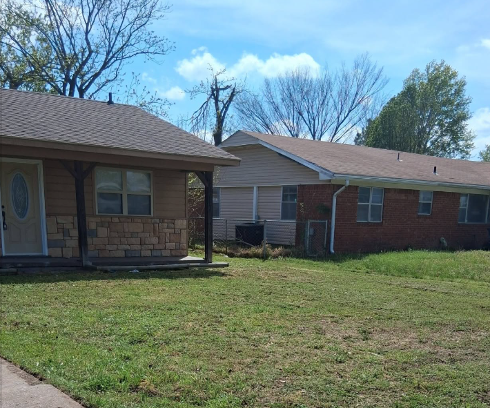Side yard mowed between two homes with trimmed edges along the drive